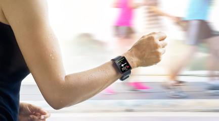 woman running with smartwatch that show heart rate on the screen