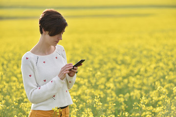 Happy woman using smartphone in the nature