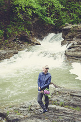 Obraz premium Happy young traveler woman hiking travelling in the forest on a sunny day. Beautiful blond hipster girl outdoors in the forest mountains near river