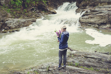 Obraz premium Happy young traveler woman hiking travelling in the forest on a sunny day. Beautiful blond hipster girl outdoors in the forest mountains near river