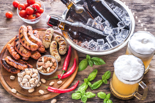 Grilled sausages with appetizers and mugs of beer