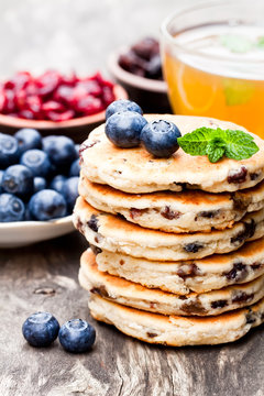 Stack  of welsh cakes with blueberry and a cup of green tea