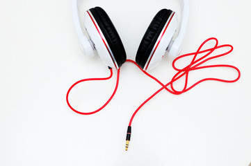 Big earphones for dj on a light table with red cable. Musical concept