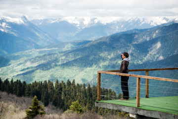 Man on a desk in mountains observing the landscape