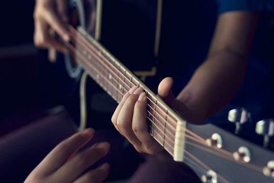 Female hands learning to play  acoustic guitar