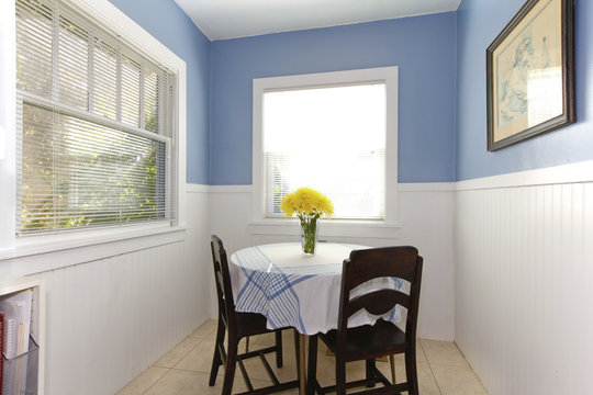 Bright small dining room with carpet windows, table and chairs