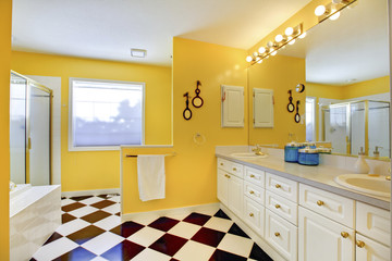 Bright yellow bathroom interior with white cabinets, tile and bi