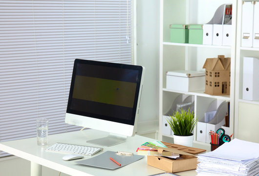 Designer working place with computer and paperwork