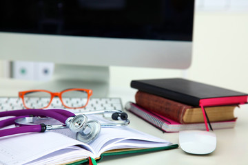 Stethoscope lying on a table on an open book