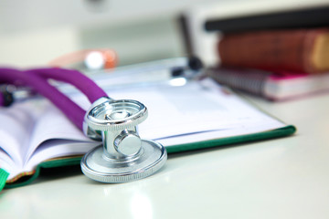 Stethoscope lying on a table on an open book