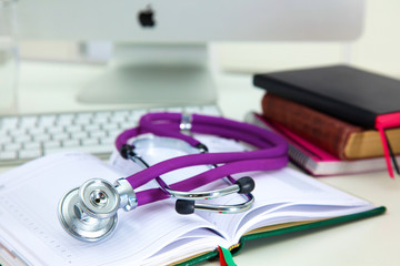 Stethoscope lying on a table on an open book