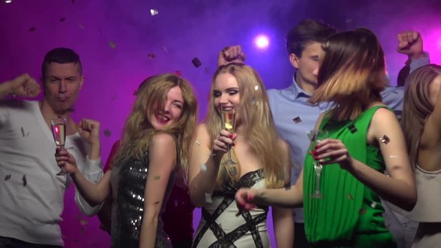 Close-up of girls dance with glass of champagne. Slow motion