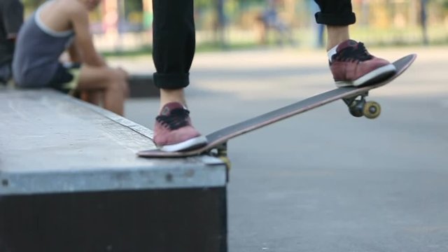 Young guy skateboarding and jumps on grindbox at skatepark