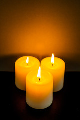 Fototapeta na wymiar closeup to burning candles in darkness