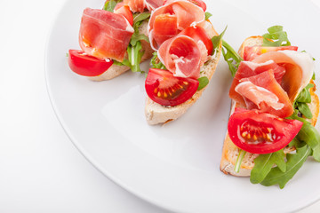 Jamon. Slices of Bread with Spanish Serrano Ham Served as Tapas. Cured ham, spanish appetizer. Prosciutto isolated on white background