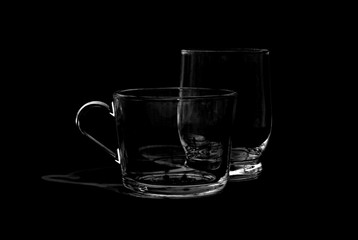 two glass cups on black background