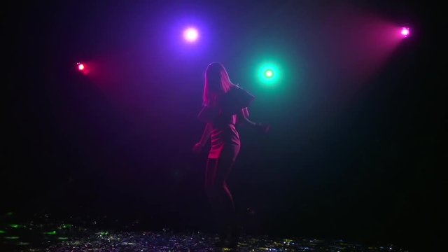 Silhouette of girl rhythmic movement of disco. Slow motion