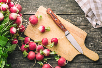 Fresh radishes on old wooden table.
