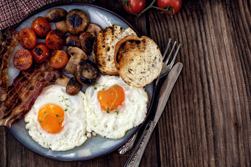 English breakfast with eggs, tomatoes, mushrooms, bacon, beans 