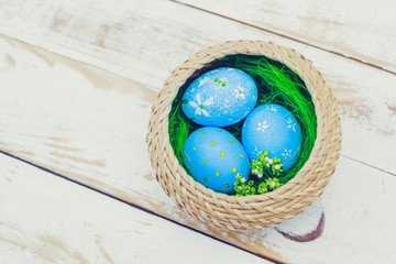 Easter eggs painted in pastel colors on white wooden background.