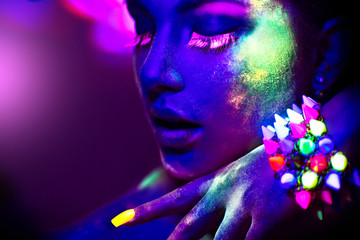Fashion model woman in neon light, portrait of beautiful model girl with fluorescent make-up