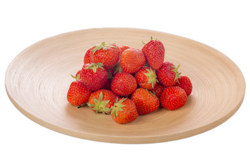 Strawberries on a wood plate isolated on white