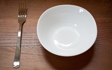 empty plate and fork on a wooden table