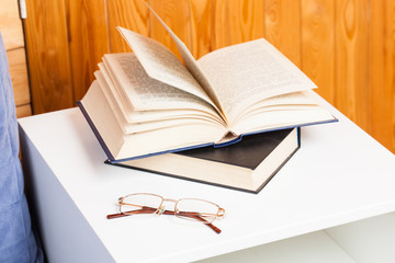 Stack of books with a pair of glasses