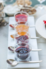Fototapeta na wymiar Different Berry Jam in Beautiful Glass Jars, Breakfast Time in Restaurant