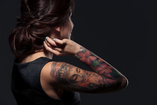 Back view of pretty young woman with tattooed hand