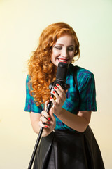 Portrait of curly-haired woman singing in mic