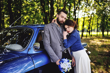 boy and girl near retro car on a forest background