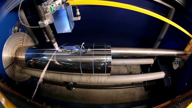 Manufacture of metal flues and ventilation systems. Timelapse footage of laser machine cuts the metal pipe.