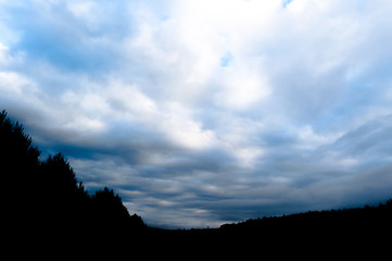 Silueta de montañas con árboles con cielo nublado