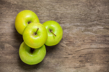 Green apples on a wooden background. Top view.