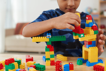Cropped image of child making creatures out of plastic bricks