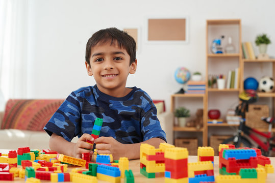 Portrait of little Indian boy playing with colorful bricks