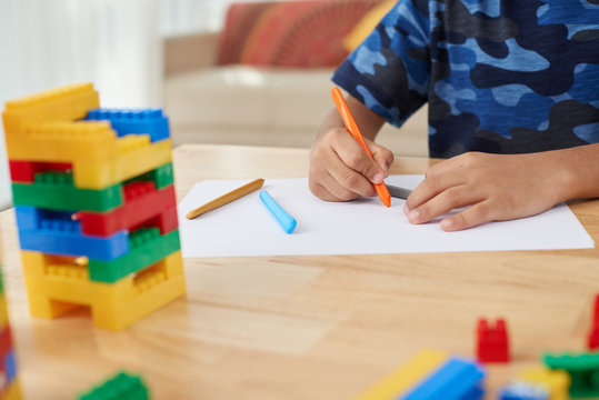 Close-up image of boy drawing with colorful pencils