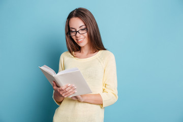 Young girl reading book over blue background