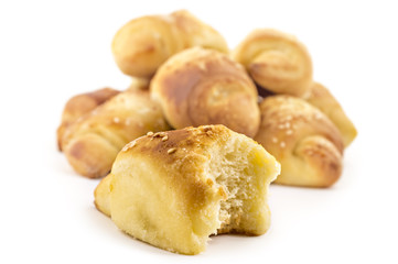 Fresh Serbian pastry rolls with cheese and sesame, kifla kiflice, one bitten, isolated on white background