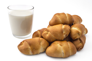 Pile of fresh bavarian pastries rolls with glass of yogurt, kifla kiflice, isolated on white background