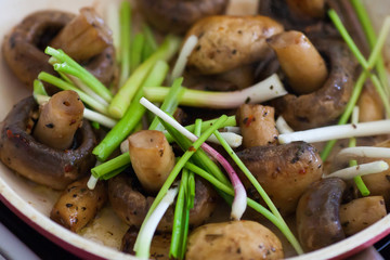 Roasted field mushrooms, champignons being cooked in frying pan