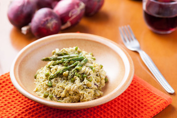 Risotto con asparagi nel piatto sulla tavola apparecchiata