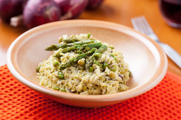 Risotto con asparagi nel piatto sulla tavola apparecchiata