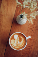 cup of coffee latte art on the wooden desk