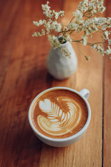 cup of coffee latte art on the wooden desk