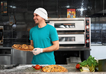 cook at table preparing a fresh pizza