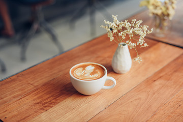 cup of coffee latte art on the wooden desk