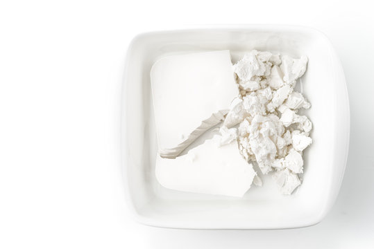 Feta cheese in the white bowl on the white background