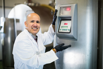 Portrait of worker near cisterns with milk